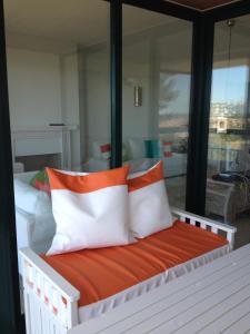 卡斯卡伊斯Apartment Outeiro da Vela的一张带橙色和白色枕头的床