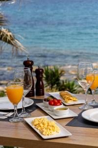 卡塔科隆PHEIA, Vriniotis Resorts的餐桌,带食物盘和橙汁杯