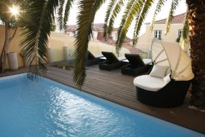 里斯本帕拉西奥瑞和特酒店的游泳池旁带躺椅和椅子的游泳池