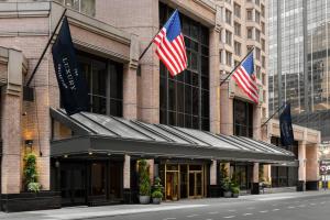 纽约The Luxury Collection Hotel Manhattan Midtown的两面美国国旗在建筑前