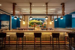 纽约The Luxury Collection Hotel Manhattan Midtown的餐厅拥有蓝色的墙壁和凳子,酒吧