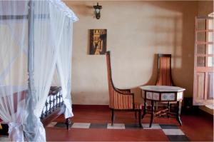 桑给巴尔米兹贾尼海滨酒店的一间设有两把椅子、一张桌子和一个窗户的房间