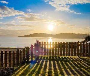 奥本Craigneuk near Oban, stunning home with sea views and EV hookup的水面上设置了一道阳光栅栏