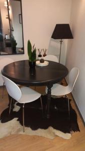 里尔Au cœur du VIEUX-LILLE : Charmant appartement的一张黑桌子,上面有白色的椅子和植物