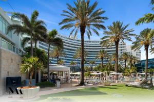 迈阿密海滩FontaineBleau Resort Balcony w Pool & Ocean View的棕榈树度假村和大型建筑