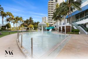 迈阿密海滩FontaineBleau Resort Balcony w Pool & Ocean View的一座大楼中央带水滑梯的游泳池