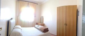 泰夫劳特HoTEL AFOULKI的一间卧室设有一张床和一个大窗户