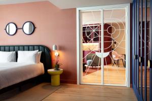 伦敦art'otel London Battersea Power Station, Powered by Radisson Hotels的一间卧室设有一张床和一个滑动玻璃门