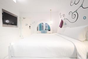 珍南海滩兰卡威达斯度假酒店的白色卧室配有白色的床和电视