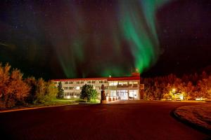 阿克雷里Hotel Kjarnalundur- Aurora Dream - Lodges and Rooms的天空中光明的办公楼