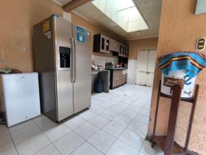 克萨尔特南戈Hostal Choja的厨房配有不锈钢冰箱和瓷砖地板。