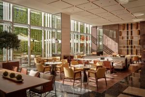 西安西安高新凯悦尚萃酒店的餐厅设有桌椅和大窗户。