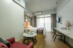 广州诺盟国际公寓广州先烈南路时代国际YOU店的酒店客房配有一张床铺和一张桌子。