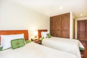 波哥大波托菲诺住宿加早餐旅馆的一间卧室设有两张床和木制橱柜