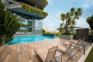 新加坡Genting Hotel Jurong的一座带椅子的游泳池以及一座建筑