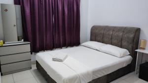 雪邦RoomStay Transit KLIA的一间卧室配有一张床和紫色窗帘