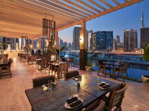 迪拜Hyde Hotel Dubai的一间带桌椅的市景餐厅