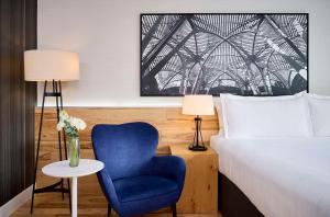 多伦多Radisson Blu Toronto Downtown的一间卧室配有一张床和一张蓝色椅子