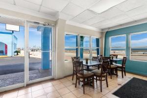 加尔维斯敦Econo Lodge Galveston Seawall的一间配备有桌椅的用餐室,享有海滩美景