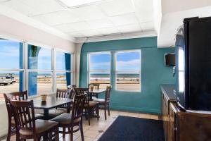 加尔维斯敦Econo Lodge Galveston Seawall的一间带桌椅和窗户的用餐室