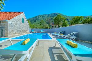 扎格沃兹德Your Ideal Haven for Serene Relaxation Villa Roglić near Baška Voda的一座带桌椅的游泳池位于酒店大楼旁