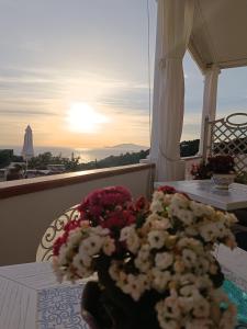 阿纳卡普里B&B Villa Cristina的阳台上的桌子上摆放着鲜花
