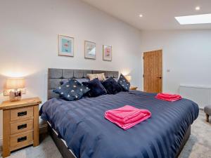 Tollerton3 Bed in Tollerton 93897的一间卧室配有一张带蓝色床单和红色毛巾的床。