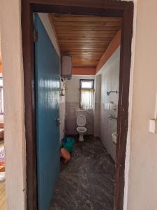 SombāriLali Gurash Homestay - Okhrey的一间带卫生间的浴室、一个窗户和一扇门