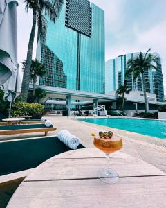 迈阿密Miami Luxury Apartments, 1 & 2 Br, Brickell Arch的在游泳池前的桌子上喝一杯