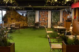 InegolRoyal Hotel Inegol的一间用餐室,配有绿色地毯和桌椅