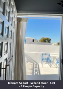 哈马马特Tunisia Queen Apartment的窗户享有带蓝椅的阳台的景致。