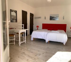 格雷乌莱班Le Mas de l'Orangerie 3 etoiles的一间卧室配有一张带红色床头板的床和一张书桌