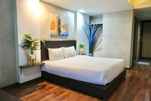 Ban Khlong PrawetBkk39 Airport hotel的一间卧室配有一张带白色床单的大床