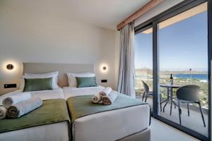 伊罗达Elounda Water Park Residence Hotel的一间带两张床的卧室,享有海景