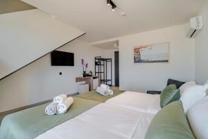 伊罗达Elounda Water Park Residence Hotel的一间带两张床和电视的卧室