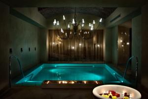 米兰蒙福特城堡罗莱夏朵精品酒店集团的配有吊灯的客房内的浴缸