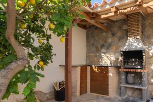 卡尔佩Maryvilla Inspiración y Vacaciones - Bungalows的户外厨房,前方有橘子树