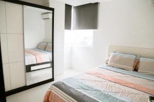 SeturanBernaung V Apartment的卧室配有镜子,位于床边