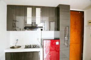 SeturanBernaung V Apartment的厨房配有水槽和红色冰箱