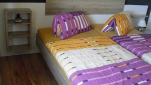 锡默拉特施洛伊夫公寓的一间卧室配有两张带紫色靠垫的床