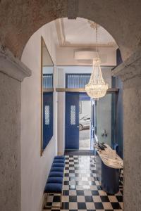 里斯本Boutique Chiado Suites的走廊设有蓝色的沙发和吊灯