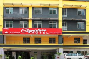 吉隆坡签名酒店@南孟沙的一座黄色的大建筑,上面有红色的标志