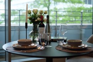 汉堡Come2Stay Hafencity - Marco Polo Tower的花瓶和酒杯的桌子