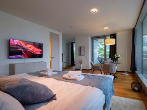 汉堡Come2Stay Hafencity - Marco Polo Tower的卧室配有一张大床,墙上配有电视