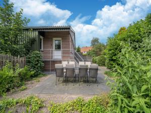 EibergenHoliday home with a view of the riding school的一组椅子坐在庭院里