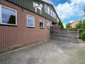 EibergenHoliday home with a view of the riding school的砖砌的建筑,旁边是马