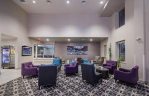 柯林斯堡La Quinta Inn & Suites by Wyndham Fort Collins, Colorado的大堂设有紫色椅子和等候室