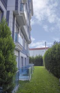 埃迪尔内高级公寓式酒店的一座建筑旁边绿色庭院的建筑