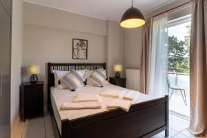 米蒂利尼Comfortable 3-Bedroom Maisonette Near the Sea的一间卧室配有一张大床和毛巾