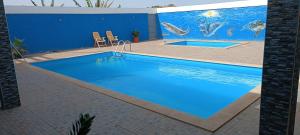 普拉亚Residência Águia的蓝色墙边的大型蓝色游泳池